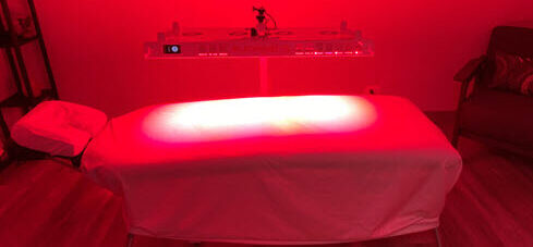 Red Light 580x580 red light therapy panel and table in room
