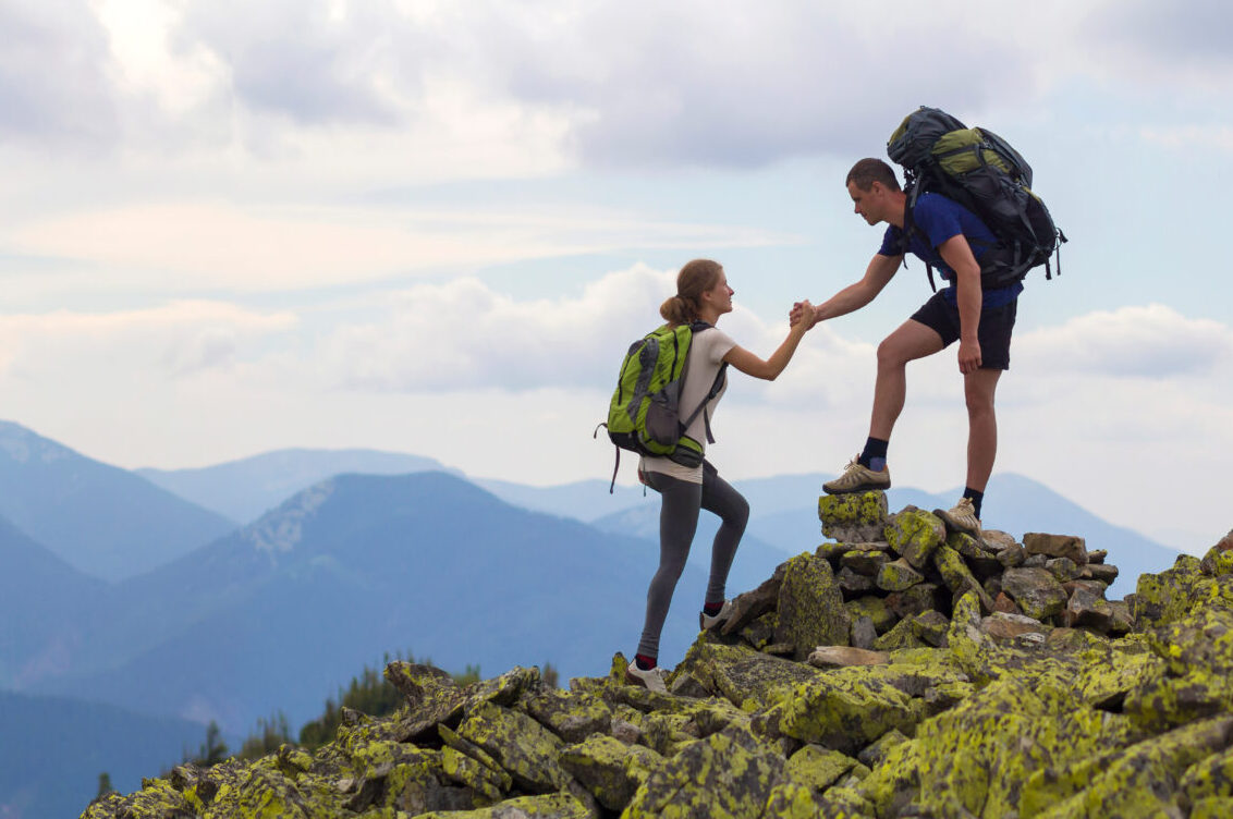 Young,Tourists,With,Backpacks,,Athletic,Boy,Helps,Slim,Girl,To